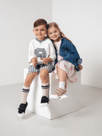 Enfants souriants portant des chaussures barefoot confortables et naturelles, pieds libres pour jouer.